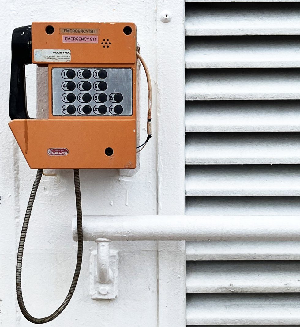 Orangefarbenes Bordtelefon an einer weißen Schiffswand